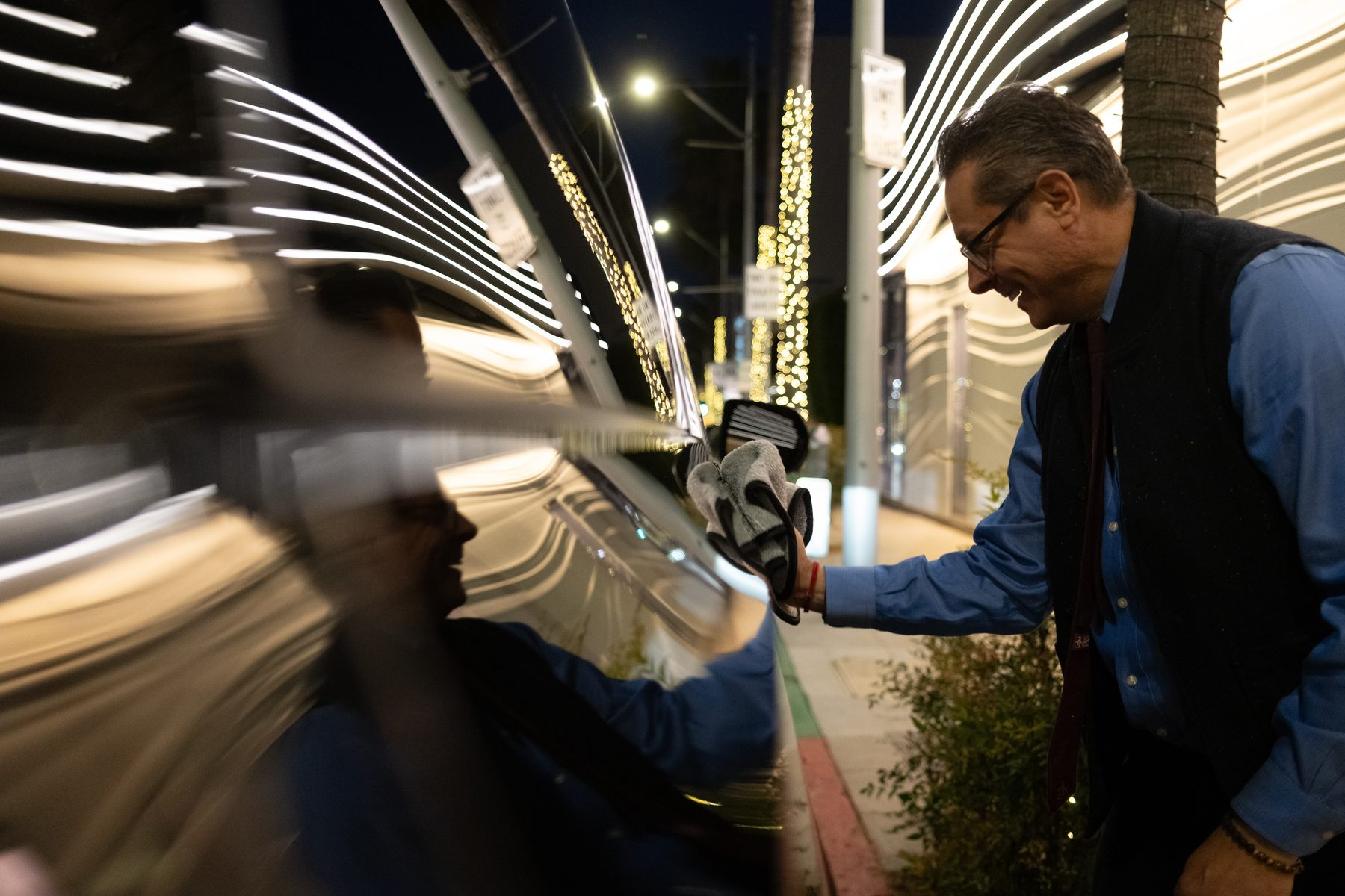 Private Premiere chauffeur detailing a vehicle before a Los Angeles evening pickup
